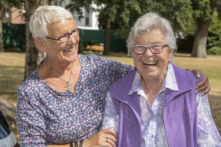 zwei lachende ältere Damen (Betreuerin u. Betreute)